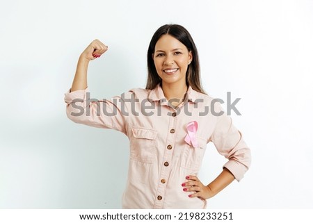 Young Brazilian woman with breast cancer ribbon over white background
