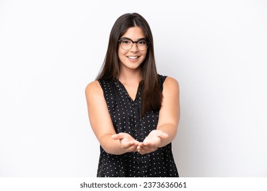 Young Brazilian woman isolated on white background holding copyspace imaginary on the palm to insert an ad