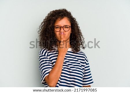 Young Brazilian woman isolated on blue background thinking and looking up, being reflective, contemplating, having a fantasy.