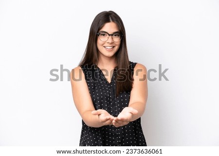 Young Brazilian woman isolated on white background holding copyspace imaginary on the palm to insert an ad