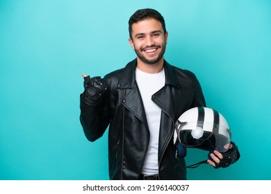 Young Brazilian woman with a motorcycle helmet isolated on blue background pointing to the side to present a product - Shutterstock ID 2196140037
