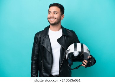 Young Brazilian woman with a motorcycle helmet isolated on blue background thinking an idea while looking up - Powered by Shutterstock