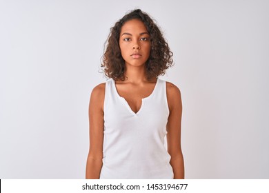 Young Brazilian Woman Wearing Casual T-shirt Standing Over Isolated White Background With Serious Expression On Face. Simple And Natural Looking At The Camera.