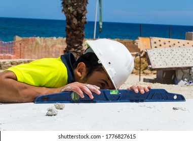 
Young Bricklayer Concentrated On The Floor Using A Level