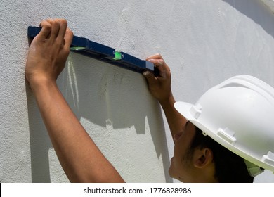 
Young Bricklayer Using A Level On The Wall 