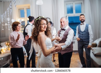 A young bride dancing with grandfather and other guests on a wedding reception. - Powered by Shutterstock