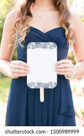 Young Bridesmaid Wearing A Navy Dress And Long Hair Holding A Blank Wedding Ceremony Program Fan