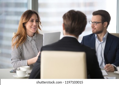 Young broker businesswoman talking to business partners. Woman consulting, giving instructions, explaining terms of contract. Man in glasses looking colleague and listening. - Shutterstock ID 1197103015
