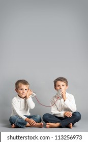 Young Brothers Talking With Tin Can Telephone.