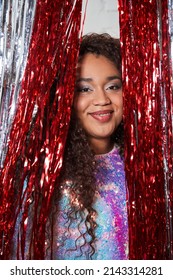 Young Brunette Female In Trendy Evening Dress Peeking From The Tinsel Curtain With Cute Face