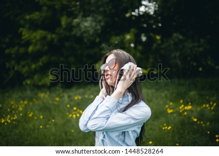 Similar – Blonde woman with black dress and sunglasses performing dance in nature with backlight