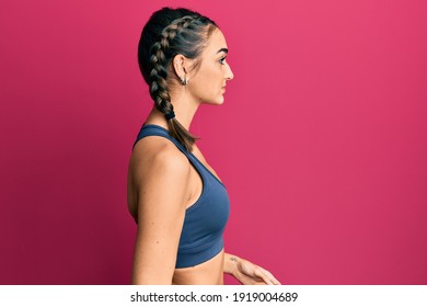 Young Brunette Girl Wearing Sportswear And Braids Looking To Side, Relax Profile Pose With Natural Face With Confident Smile. 