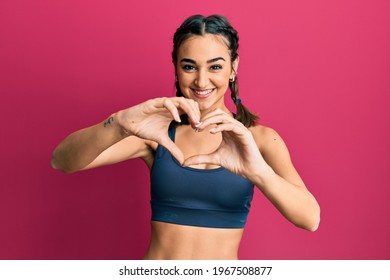 Young brunette girl wearing sportswear and braids smiling in love doing heart symbol shape with hands. romantic concept.  - Powered by Shutterstock