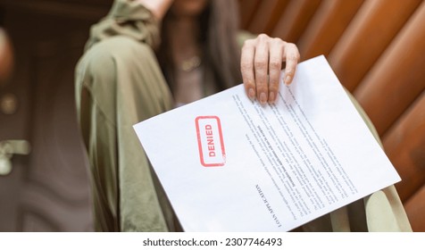 Young brunette long hair girl cries hysterically after being denied a mortgage loan. Depressive sad eviction female millenial holding rejection document copy space banner - Shutterstock ID 2307746493