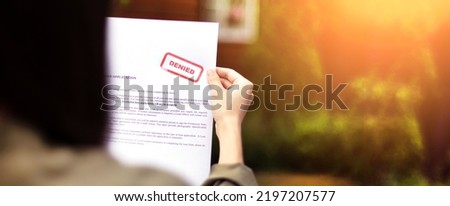 Young brunette long hair girl cries hysterically after being denied a mortgage loan.Depressive sad state female millenial holding  rejection document copy space banner