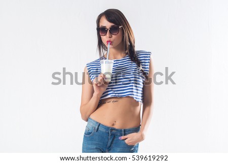 Young brunette model posing drinking cocktail studio shot on white background, not isolated