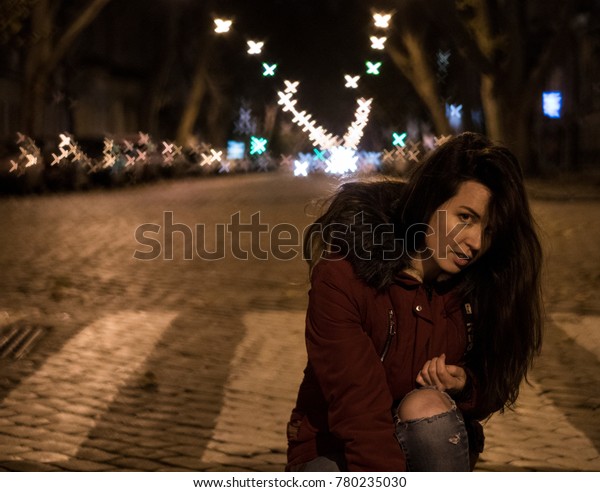 Young Brunette on the Street with bizarre bokeh\
shapes. Anamorphic lens