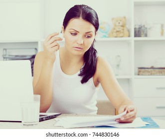 Young brunette sad woman working at laptop
