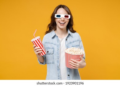 Young Brunette Smiling Happy Excited Woman In 3d Glasses Watch Movie Film, Hold Bucket Of Popcorn Cup Of Soda Isolated On Yellow Background Studio Portrait. People Emotions In Cinema Lifestyle Concept