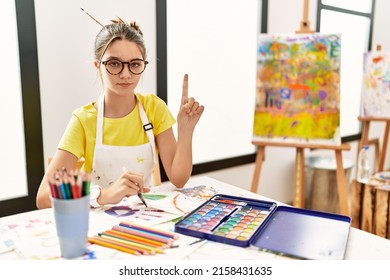 Young Brunette Teenager At Art Studio Pointing With Finger Up And Angry Expression, Showing No Gesture 