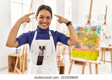 Young Brunette Woman At Art Studio Smiling Pointing To Head With Both Hands Finger, Great Idea Or Thought, Good Memory 