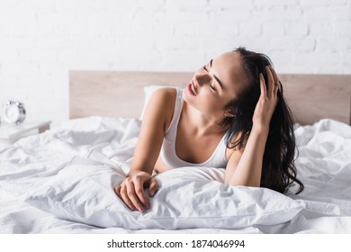 young brunette woman in bed with closed eyes