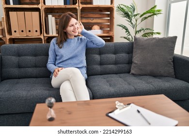 Young Brunette Woman At Consultation Office Smiling With Hand Over Ear Listening An Hearing To Rumor Or Gossip. Deafness Concept. 