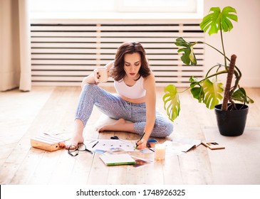 Young brunette woman creating her Feng Shui wish map using scissors. Dreams and wishes