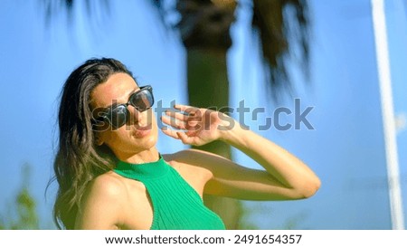 Brunette surfer woman in bikini standing with surfboard