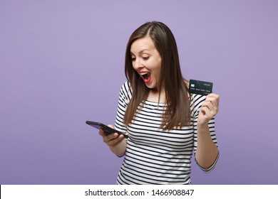 Young brunette woman girl in casual striped clothes posing isolated on violet purple background studio portrait. People lifestyle concept. Mock up copy space. Hold in hand credit bank card cellphone - Shutterstock ID 1466908847