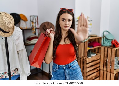 Young Brunette Woman Holding Shopping Bags At Retail Shop Doing Stop Sing With Palm Of The Hand. Warning Expression With Negative And Serious Gesture On The Face. 