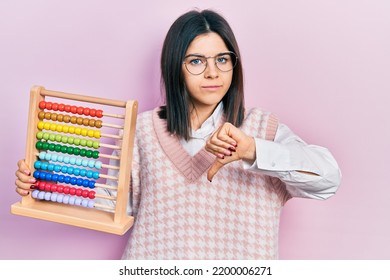 Young Brunette Woman Holding Traditional Abacus With Angry Face, Negative Sign Showing Dislike With Thumbs Down, Rejection Concept 