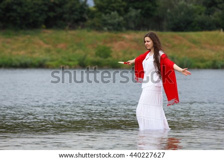 Young brunette woman with Italian knife at a lake