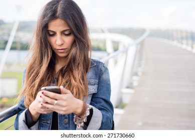 Young Brunette Woman Looking Her Smart Phone Outdoors