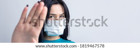 A young brunette woman in a medical mask