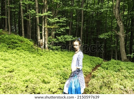 young brunette woman on a path in the Carpathian forest, summer, Ukraine, boho style clothes

