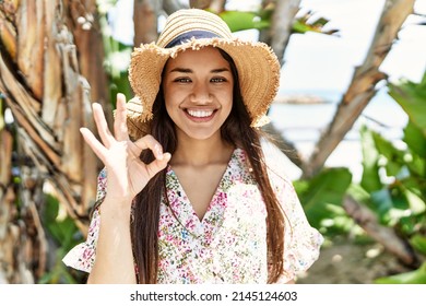 Young brunette woman outdoors on a sunny day of summer surprised with an idea or question pointing finger with happy face, number one 