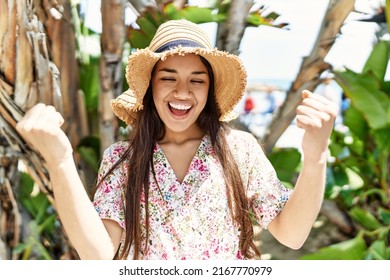 Young brunette woman outdoors on a sunny day of summer smiling happy pointing with hand and finger to the side 