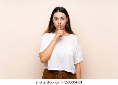 Young brunette woman over isolated background showing a sign of silence gesture putting finger in mouth