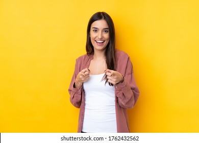 Young brunette woman over isolated yellow background pointing to the front and smiling - Shutterstock ID 1762432562