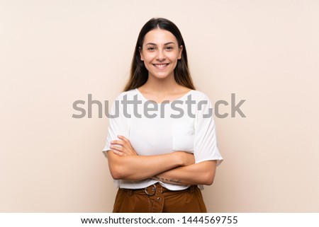 Young brunette woman over isolated background keeping the arms crossed in frontal position