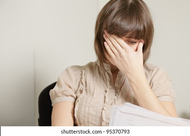 Young Brunette Woman Reading Report Covering Face With Palm