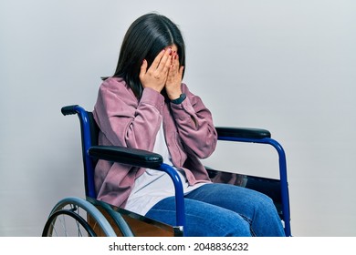 Young brunette woman sitting on wheelchair with sad expression covering face with hands while crying. depression concept.  - Powered by Shutterstock