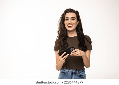 Young brunette woman smiling while using cellphone isolated over white background - Shutterstock ID 2285444879