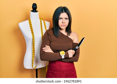 Young Brunette Woman Standing By Manikin Holding Scissors Skeptic And Nervous, Frowning Upset Because Of Problem. Negative Person. 