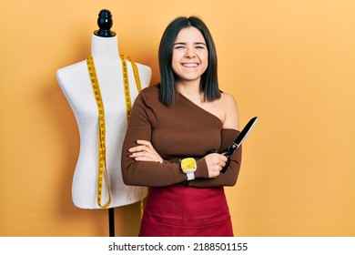 Young Brunette Woman Standing By Manikin Holding Scissors Smiling And Laughing Hard Out Loud Because Funny Crazy Joke. 