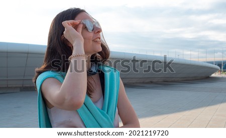Young brunette woman in sunglasses on an evening walk, summer, portrait outdoors
