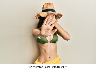 Young Brunette Woman Wearing Bikini Covering Eyes With Hands And Doing Stop Gesture With Sad And Fear Expression. Embarrassed And Negative Concept. 