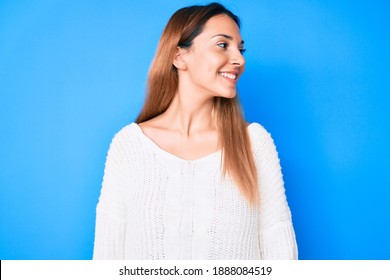 Young Brunette Woman Wearing Casual Sweater Looking Away To Side With Smile On Face, Natural Expression. Laughing Confident. 