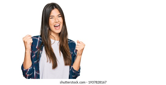 Young brunette woman wearing casual clothes screaming proud, celebrating victory and success very excited with raised arms 
